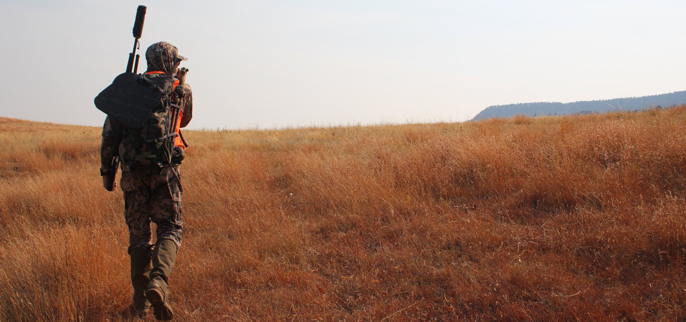 Hunter hiking through open western country